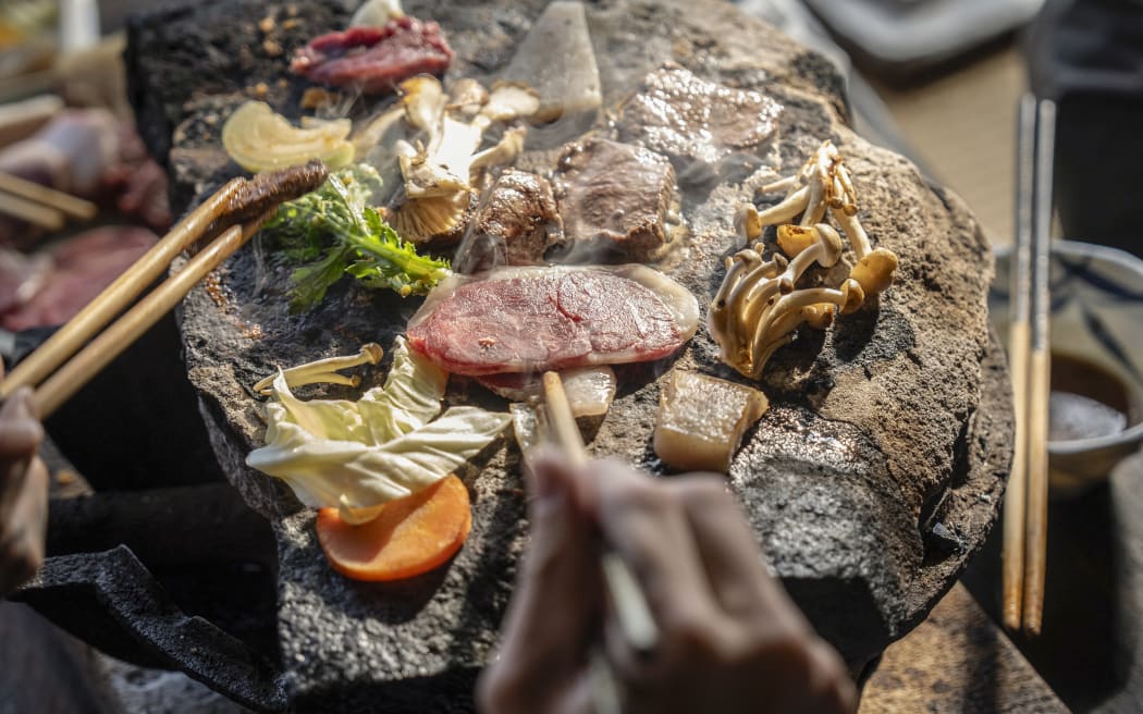 This picture shows people cooking bear meat and vegetables at a restaurant in Chichibu, Saitama prefecture.