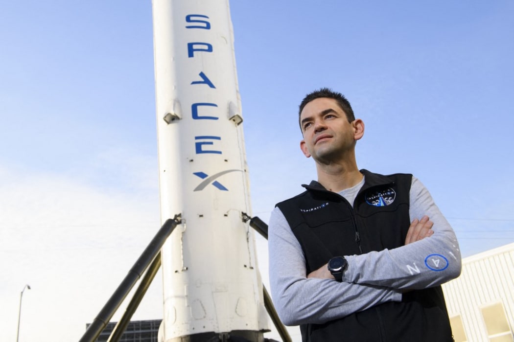 (FILES) In this file photo taken on February 02, 2021 Inspiration4 mission commander Jared Isaacman, founder and chief executive officer of Shift4 Payments, stands for a portrait in front of the recovered first stage of a Falcon 9 rocket at Space Exploration Technologies Corp.