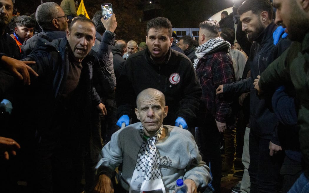 A crowd welcomes Palestinians formerly jailed by Israel as they arrive in a Red Cross convoy to Ramallah in the occupied West Bank on January 30, 2025. Buses carrying freed Palestinian prisoners arrived to cheers in the occupied West Bank on January 30, 2025, after chaos during the release by Gaza militants of three Israeli hostages and five Thais led to a brief delay in the process. (Photo by Wahaj Bani Moufleh / Middle East Images / Middle East Images via AFP)