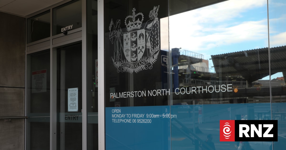 Exterior of the Palmerston North Courthouse with the New Zealand coat of arms displayed on the glass.
