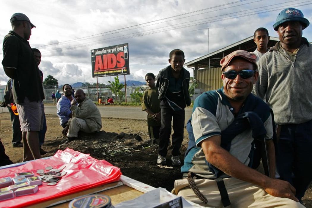 Residents sell their goods near a anti-Aids billboard in Mount Hagen, 18 August 2007.