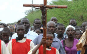 boy carrying cross at Easter parade