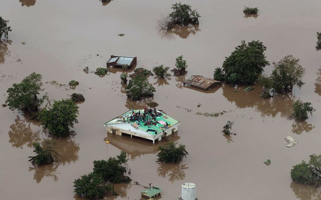 People on a roof surrounded by flooding in Beira region.