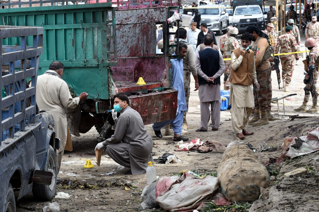 Pakistani security officials inspect the site of a bomb blast at a fruit market in Quetta on April 12, 2019. At least 16 people were killed and 30 wounded in a powerful blast on April 12.
