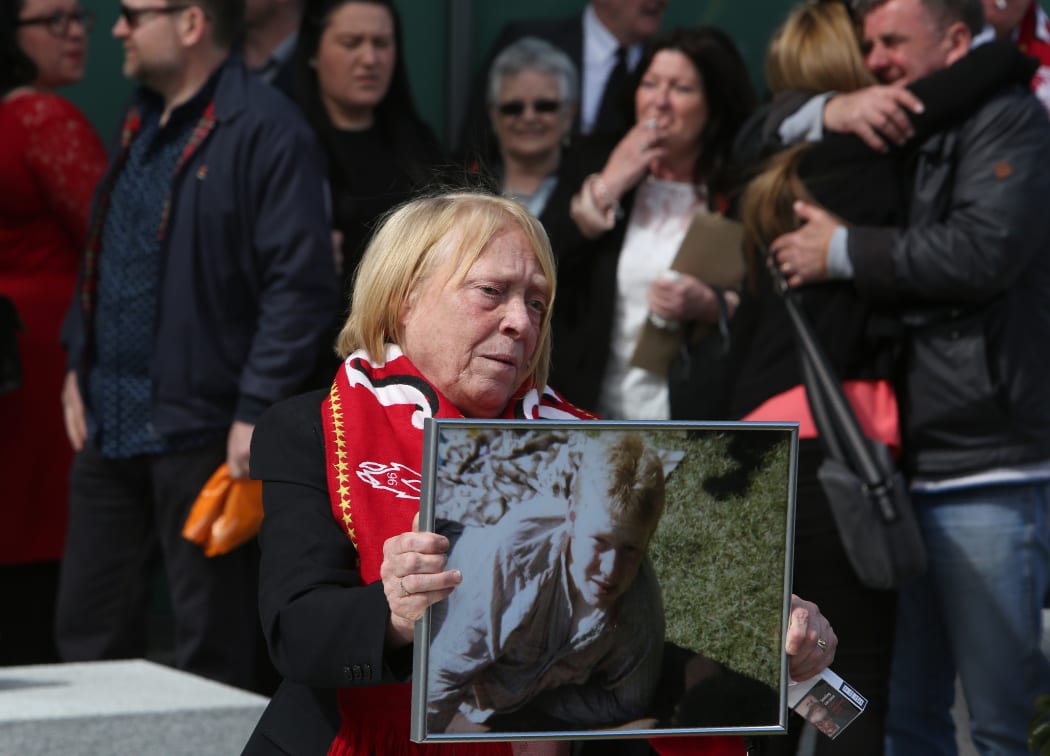 A woman holds an image of Keith McGrath, victim of the 1989 Hillsborough disaster.