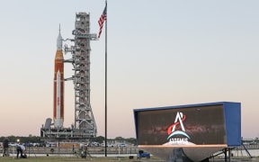 The massive Artemis I rocket rolls past the countdown clock atop a mobile launch platform en route to Launch Pad 39B from the Vehicle Assembly Building at the Kennedy Space Center in Florida March 17, 2022.