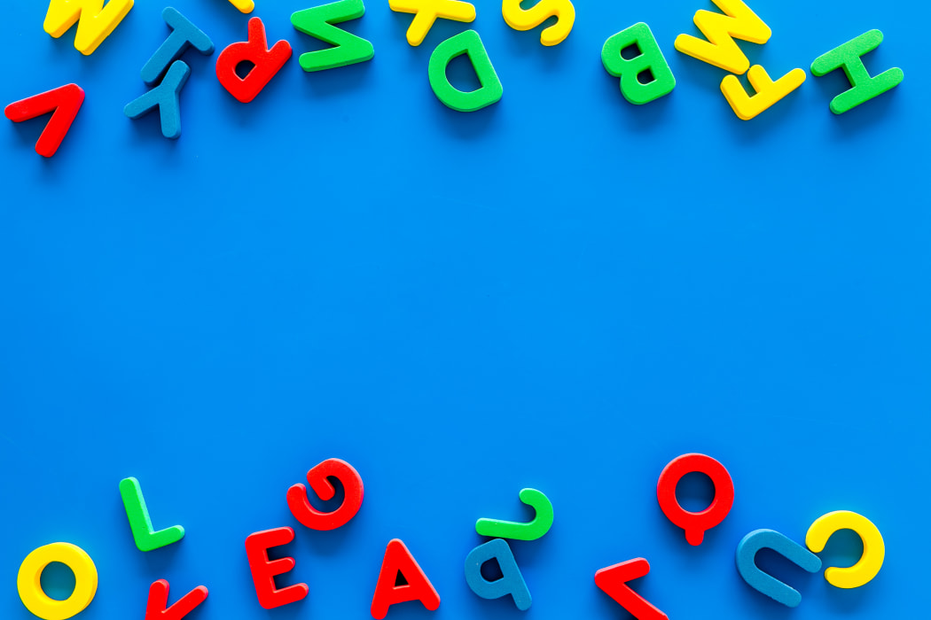 Alphabet for kids concept. English letters in disorder on blue background top view.