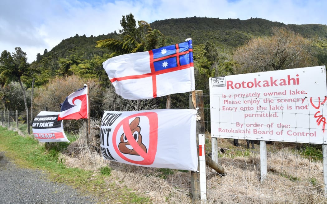 Signs against a sewerage scheme at sacred Lake Rotokākahi. Photo / Laura Smith