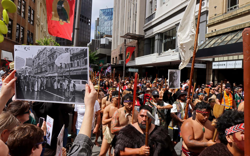 John Miller's photograph of the 1975 land march held up in the same location at the 2024 Hīkoi in Pōneke Wellington