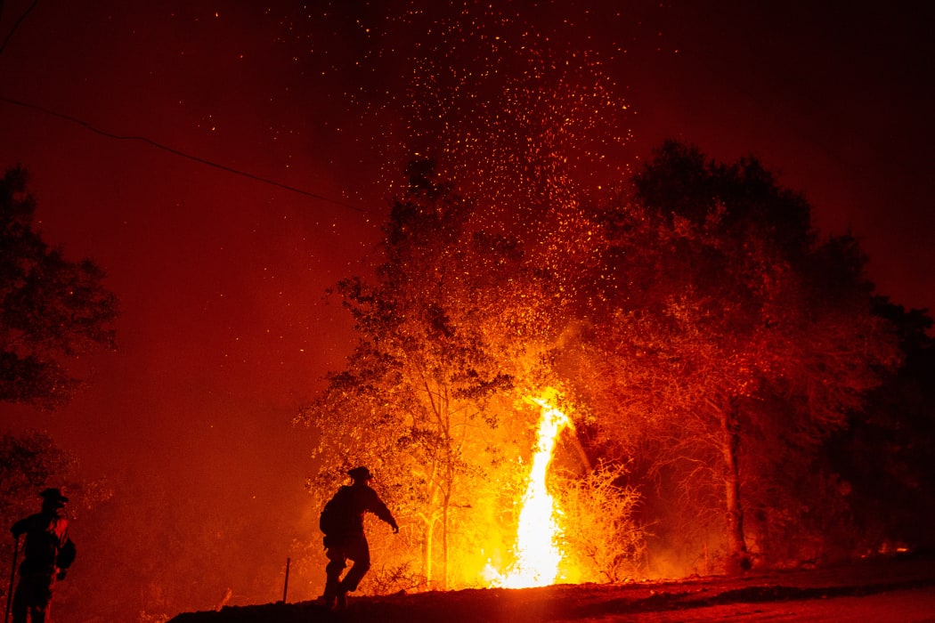Firefighters monitor a backfire during the Carr fire in Redding, California