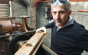 Peter Tantrum stands inside the engine room of the elevator.