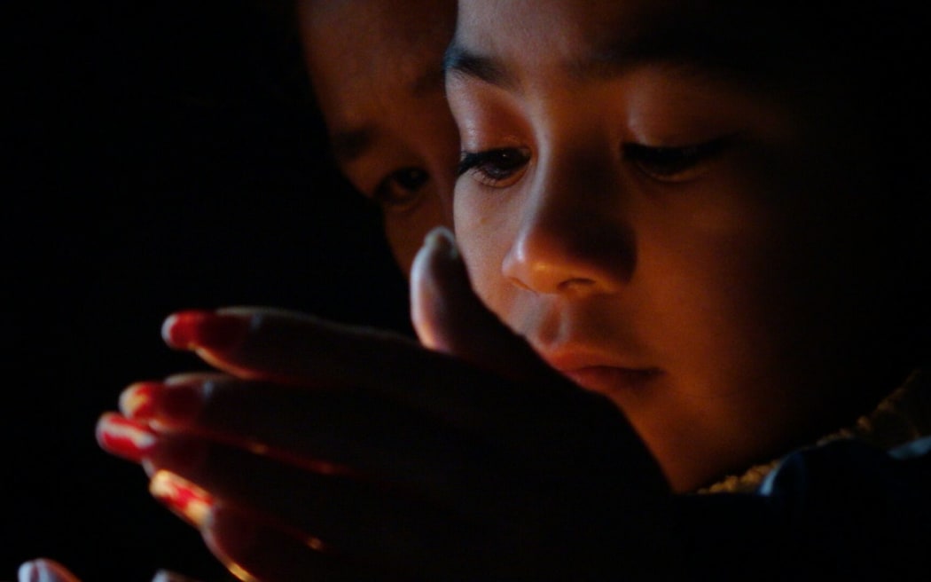 Children light candles at the vigil.