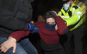 Police officers scuffle with people gathering at a band-stand where a planned vigil in honour of murder victim Sarah Everard was cancelled after police outlawed it due to Covid-19 restrictions.