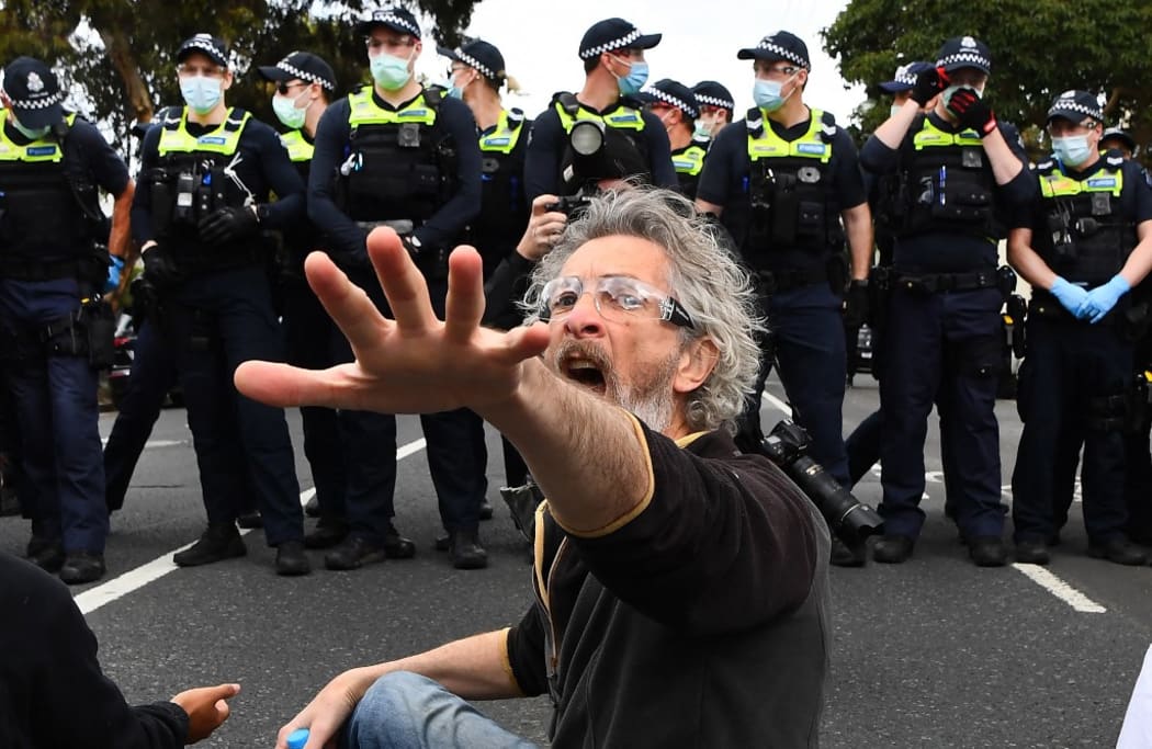 A protester confronts police during an anti-lockdown rally in Melbourne on September 18, 2021.