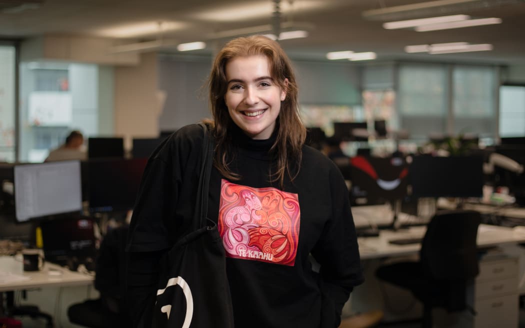 'The Detail' producer Bonnie wearing a tee from NZ artist Theia's latest music project 'Te Kaahu'.