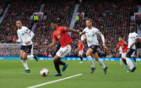 Marcus Rashford of Manchester United is surrounded by Liverpool defenders.