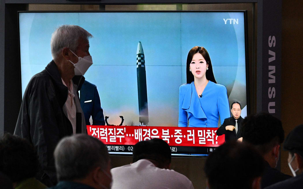 A man walks past a screen showing a news broadcast with file footage of a North Korean missile test, at a railway station in Seoul, South Korea on 5 June, 2022.