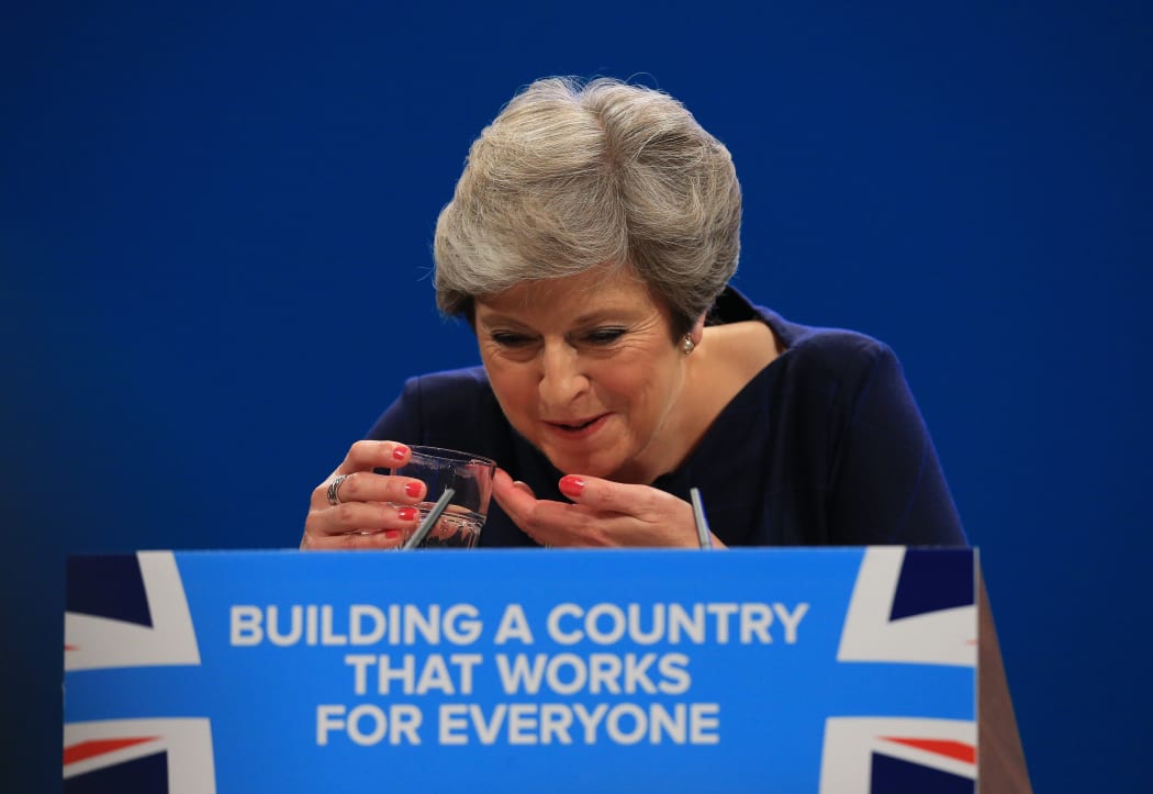 Theresa May splutters as she drinks water while losing her voice during her keynote speech.