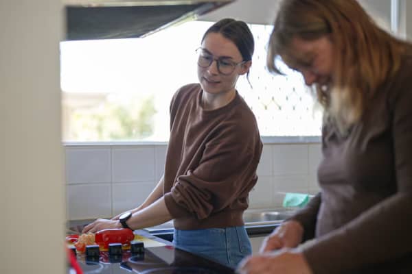 Hayley and her support worker Camille cooking in the kitchen.