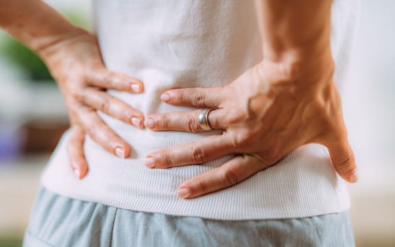 Woman with sciatic nerve pain in her lower back. (Photo by MICROGEN IMAGES/SCIENCE PHOTO LI / SMD / Science Photo Library via AFP)