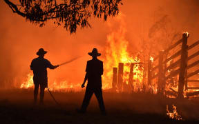 Residents defend a property from a bushfire at Hillsville near Taree, 350km north of Sydney on November 12, 2019