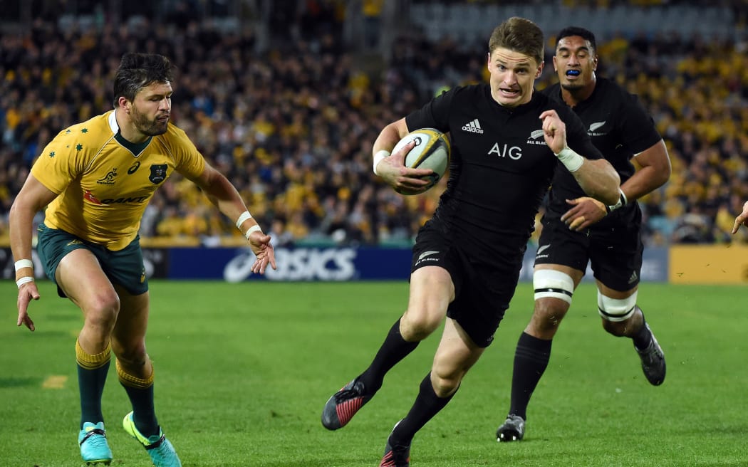 Beauden Barrett runs for a successful try as Australia's Adam Ashley-Cooper looks on.