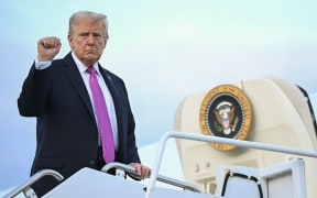 US President Donald Trump raises his fist as he boards Air Force One on 14 September, 2025.