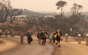 Evacuees walking to the beach to board a navy ship to escape fires at Mallacoota, Victoria, on 3 January 2020.