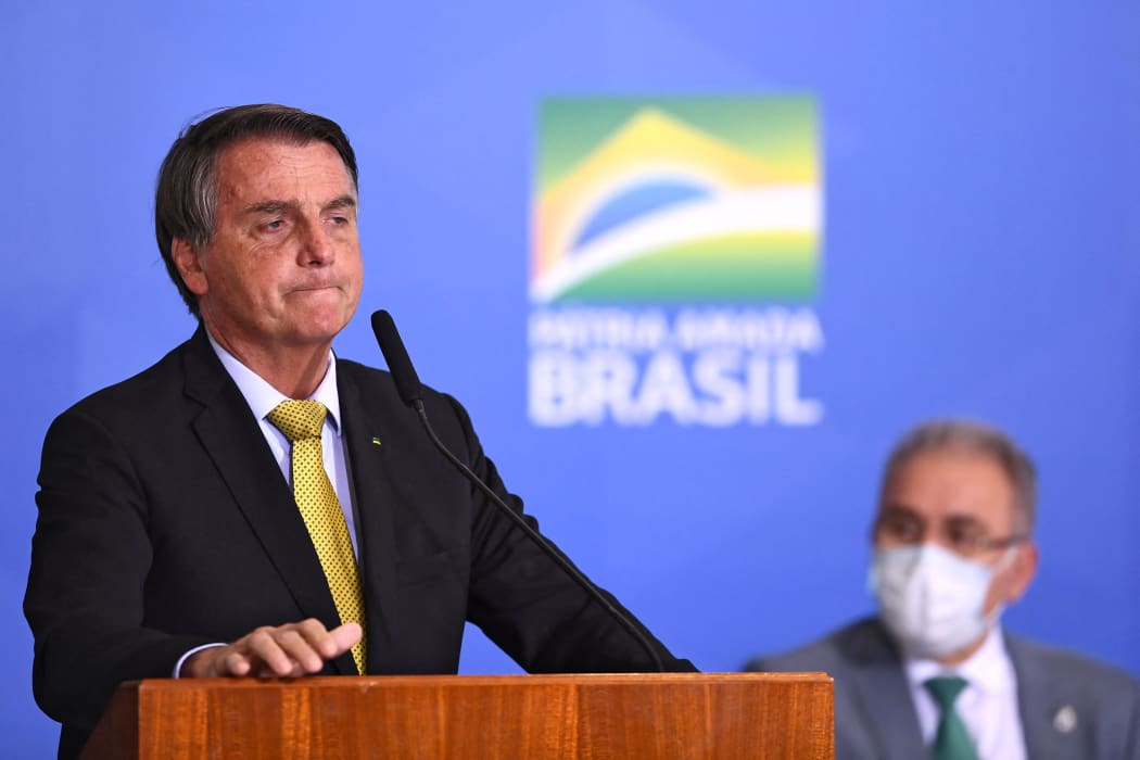 Brazilian President Jair Bolsonaro (L) speaks near Health Minister Marcelo Queiroga during the launching ceremony of a new registry of professional fishermen, at Planalto Palace in Brasilia on June 29, 2021.