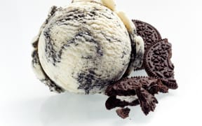 Speciality American oreo ice cream with crushed cookies alongside as ingredients isolated on white showing the texture of the scoop