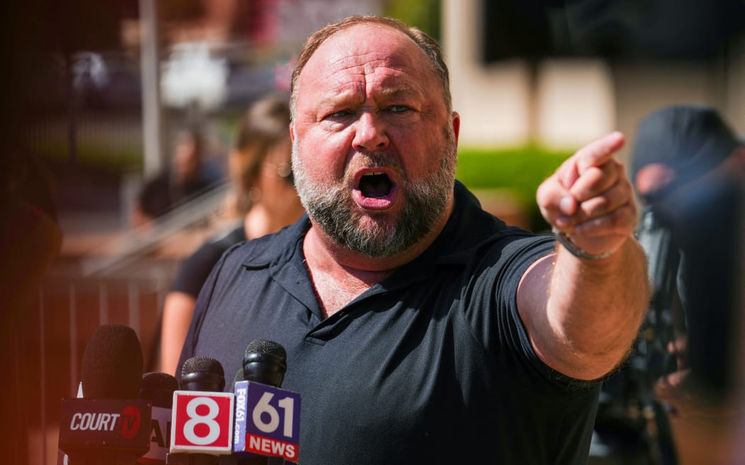 WATERBURY, CONNECTICUT - SEPTEMBER 21: InfoWars founder Alex Jones speaks to the media outside Waterbury Superior Court during his trial on September 21, 2022 in Waterbury, Connecticut. Jones is being sued by several victims' families for causing emotional and psychological harm after they lost their children in the Sandy Hook massacre. A Texas jury last month ordered Jones to pay $49.3 million to the parents of 6-year-old Jesse Lewis, one of 26 students and teachers killed in the shooting in Newtown, Connecticut.   Joe Buglewicz/Getty Images/AFP (Photo by Joe Buglewicz / GETTY IMAGES NORTH AMERICA / Getty Images via AFP)
