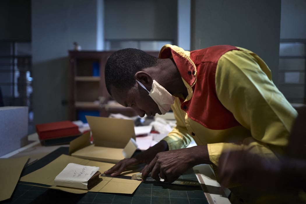 A Malian student makes a box to store and preserve the ancient manuscripts of Timbuktu on March 31, 2021.