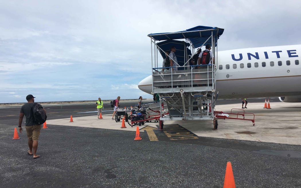 Passengers board a United Airlines flight in Majuro. For the first time in late January, Marshall Islands Immigration officials detained several passengers at Majuro's international airport for questioning in relation to participation in illegal adoptions in the United States.