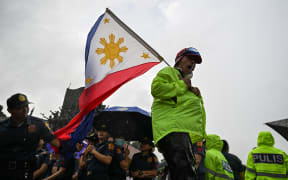 Protesters take part in a rally as they demonstrate against corruption following the revelations over bogus flood control projects, one of the country's biggest corruption scandals in decades, at the People Power Monument in Quezon City, Metro Manila on September 21, 2025. Thousands of Filipinos marched in Manila on September 21 to vent their anger over a ballooning scandal involving bogus flood-control projects believed to have cost taxpayers billions of dollars. (Photo by Jam STA ROSA / AFP)