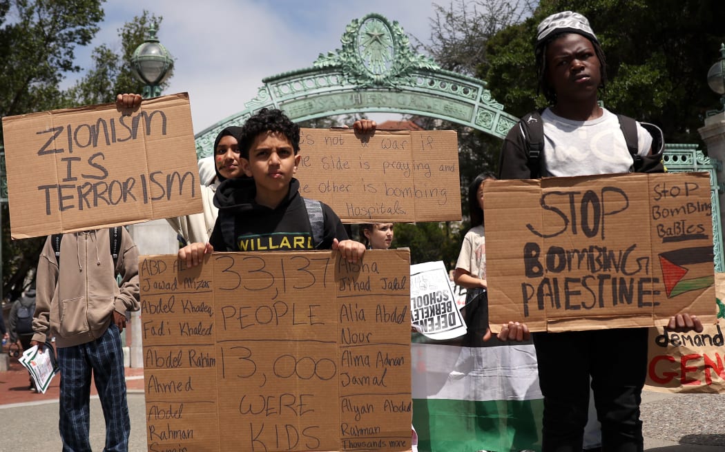 BERKELEY, CALIFORNIA - APRIL 22: Pro-Palestinian protesters carry signs as they march in front of Sather Gate on the UC Berkeley campus on April 22, 2024 in Berkeley, California. Hundreds of pro-Palestinian protesters staged a demonstration in front of Sproul Hall on the UC Berkeley campus where they set up a tent encampment in solidarity with protesters at Columbia University who are demanding a permanent cease-fire in the war between Israel and Gaza.   Justin Sullivan/Getty Images/AFP (Photo by JUSTIN SULLIVAN / GETTY IMAGES NORTH AMERICA / Getty Images via AFP)