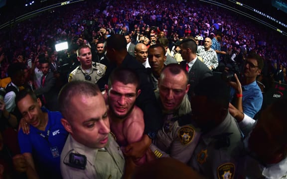 Khabib Nurmagomedov of Russia is escorted out of the arena after defeating Conor McGregor.