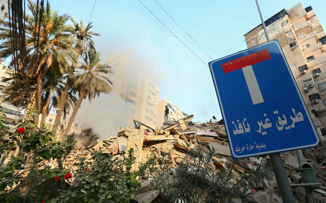 A man stands above debris of destroyed buildings behind a dead end sign at Beirut's southern suburb Haret Hreik neighbourhood on October 10, 2024, following overnight Israeli strikes. - The United States urged its ally Israel to avoid Gaza-like military action in Lebanon, after Prime Minister Benjamin Netanyahu said it could face "destruction" like the Palestinian territory. (Photo by AFP)