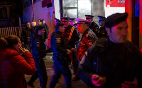 Emergency service and police forces gather near a club in Bucharest.