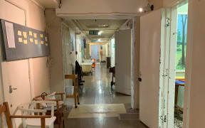 Hallway at the Porirua Hospital Museum filled with old chairs and medical equipment.