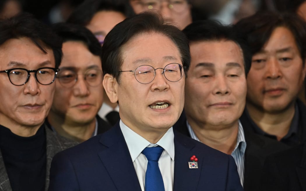 South Korea's main opposition Democratic Party leader Lee Jae-myung (C) speaks to the media at the National Assembly in Seoul on December 4, 2024, after South Korea President Yoon Suk Yeol declared martial law. - Yoon on December 3 declared martial law, accusing the opposition of being "anti-state forces" and saying he was acting to protect the country from "threats" posed by the North. (Photo by Jung Yeon-je / AFP)