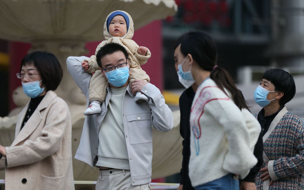 A baby is carried on the shoulders of a man in Beijing in March 2021.