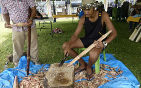 A student on Niue learns to carve in a traditional way.