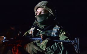 A Ukrainian soldier stands guard during the prisoner exchange.