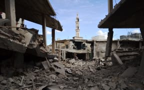 A picture taken on September 30, 2015 shows damaged buildings and a minaret in the central Syrian town of Talbisseh in the Homs province.