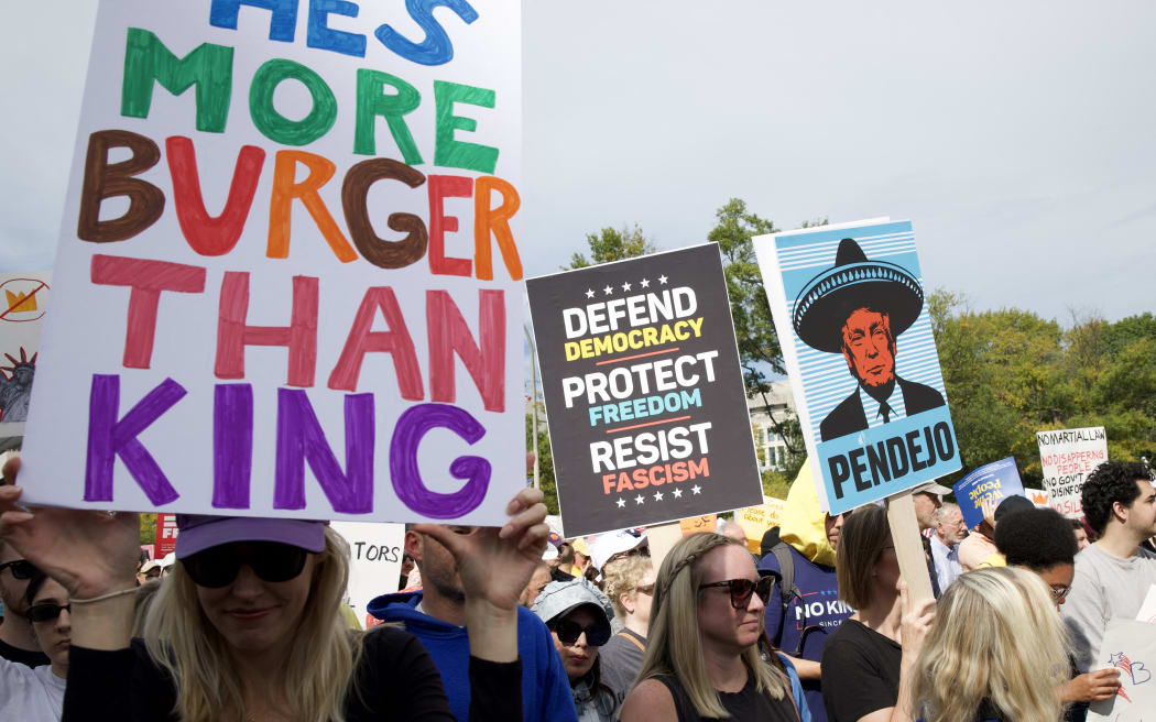 People participate in a "No Kings" national day of protest in Washington, DC, on October 18, 2025. From New York to San Francisco, millions of Americans are expected to hit the streets to voice their anger over President Donald Trump's policies at nationwide "No Kings" protests. (Photo by Amid FARAHI / AFP)
