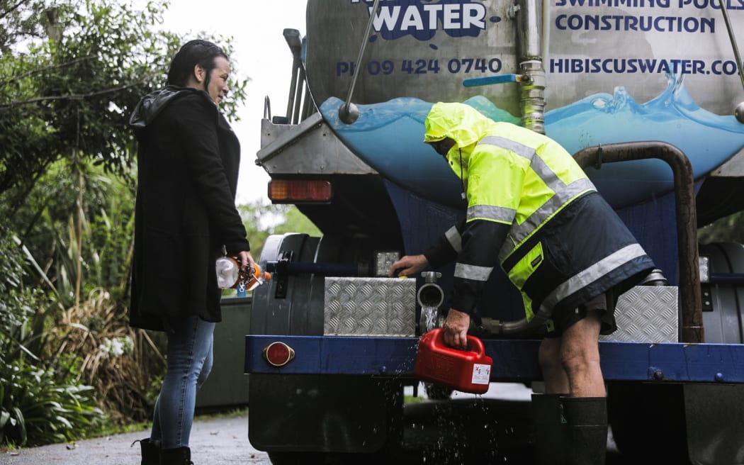 Auckland flooding - giving out water on South Titirangi Rd