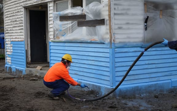 A water-proof membrane designed to protect flood-prone houses is sprayed on.