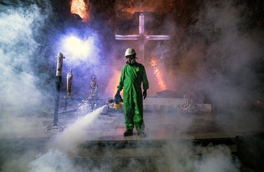 A worker disinfects the Salt Cathedral of Zipaquira, an underground church built into a salt mine, in Colombia on August 30, 2020.