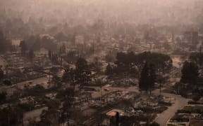 Smoke lingers over a neighborhood devastated by the Eaton Fire, on January 9, in Altadena, California. Southern California Edison, the electrical utility for Los Angeles, has been sued for its alleged role in starting one of the raging Los Angeles fires.