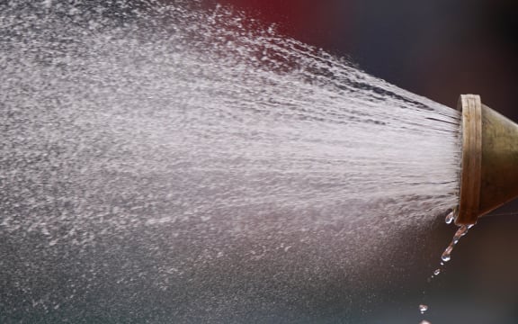 Groundstaff members sprays water on the tennis court during the men's singles first round match on day 1 of The Roland Garros 2019 French Open tennis tournament in Paris on May 26, 2019. (Photo by Kenzo TRIBOUILLARD / AFP)